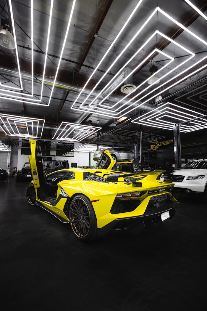 Sprowadzanie samochodów z Europy – co warto wiedzieć, zanim kupisz auto za granicą Yellow Lamborghini Aventador with open doors in a modern garage setting.