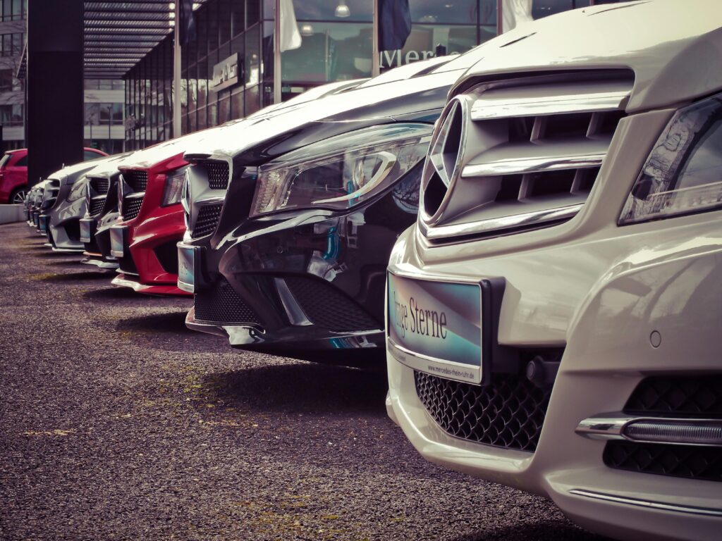 pexels photo 164634 164634 Luxury cars lined up at an outdoor dealership, showcasing sleek designs.